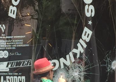 Person touches shattered window of store on Broadway in Soho New York June 2020